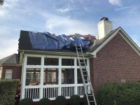 Residential roof with a tarp in the process of getting a replacement